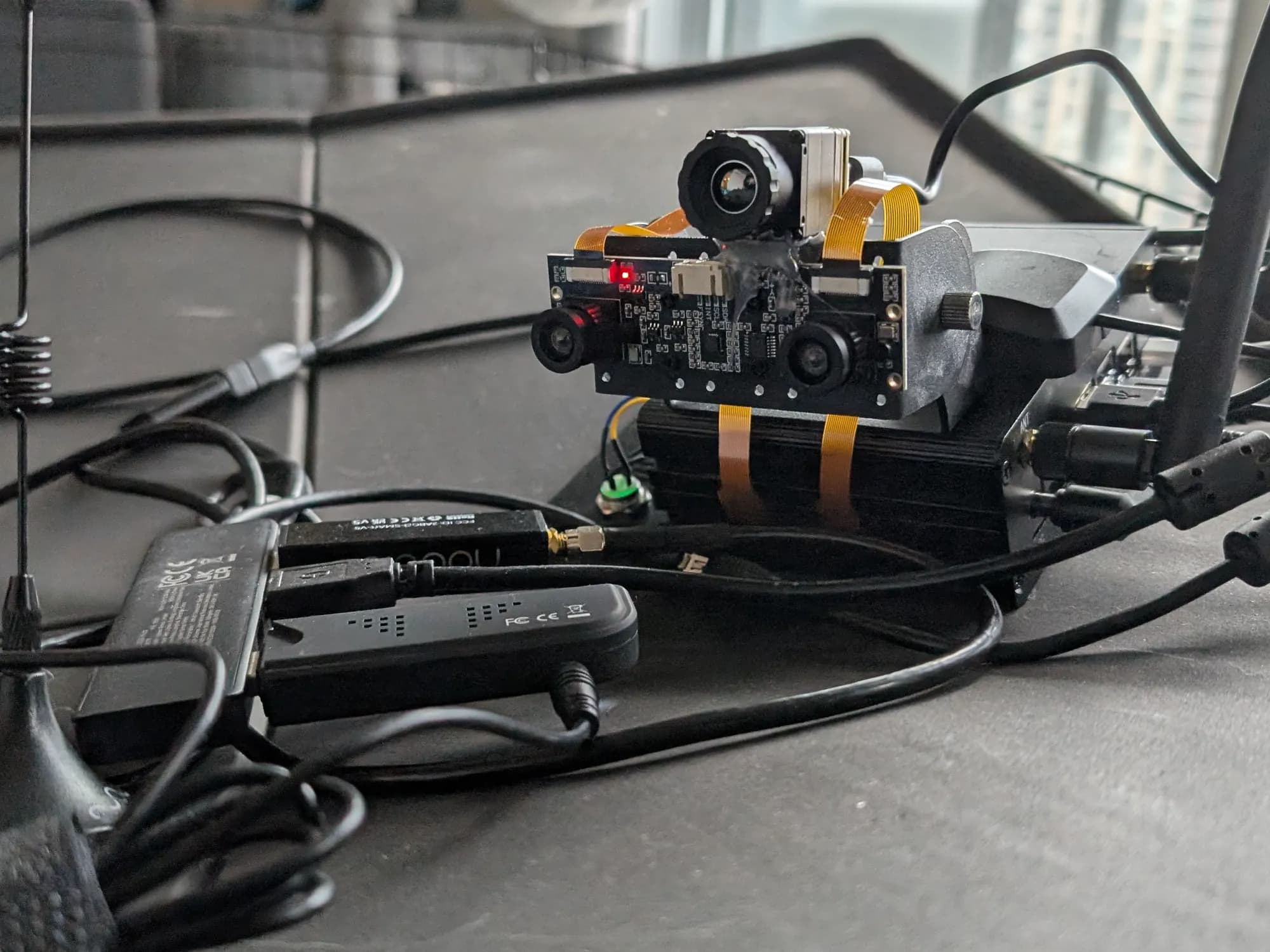 DeepVision EVS Mk. 1 prototype on a desk: a thermal camera above a stereo camera board on a Jetson Orin Nano, with SDR dongles and antennas around it.